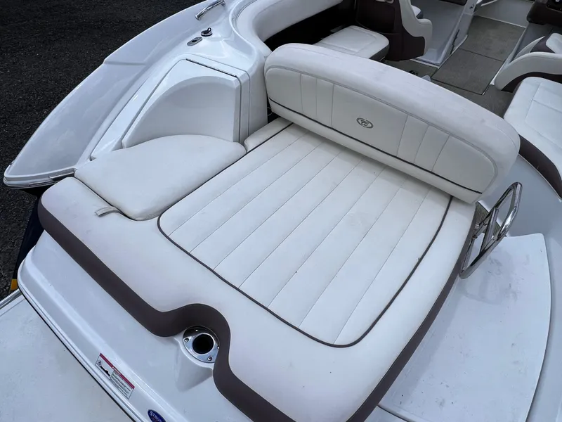 Slide: The Image of 2013 Cobalt 262 boat interior with white cushioned seating and sleek design. - 12