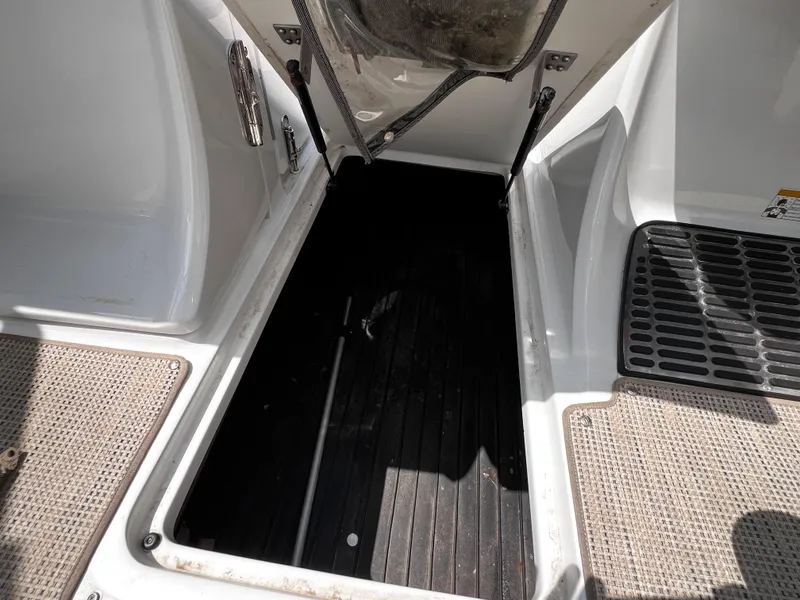 Slide: The Image of Open storage compartment on a 2013 Cobalt 262 boat, featuring rubber mat flooring. - 14
