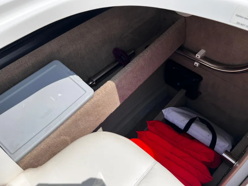 Slide: The Image of Storage compartment in a 2013 Cobalt 262 boat with life jackets and a storage box. - 17