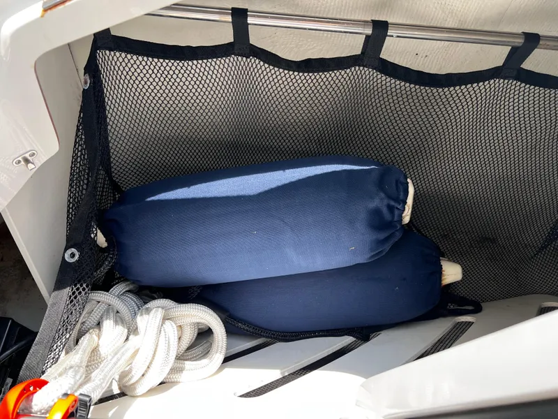 Slide: The Image of Storage compartment in a 2013 Cobalt 262 boat with blue fenders and white rope. - 18