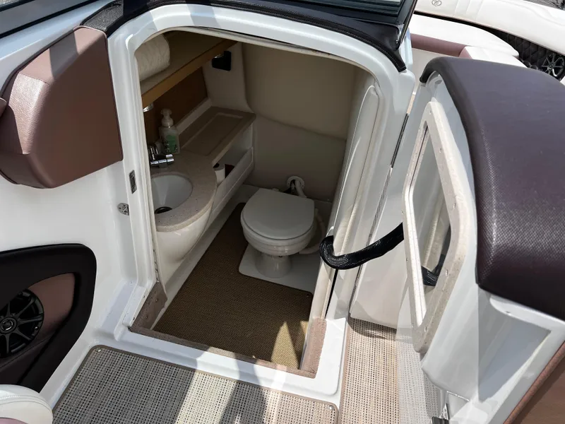 Slide: The Image of Interior of a 2013 Cobalt 262 boat featuring a compact bathroom with sink and toilet. - 9