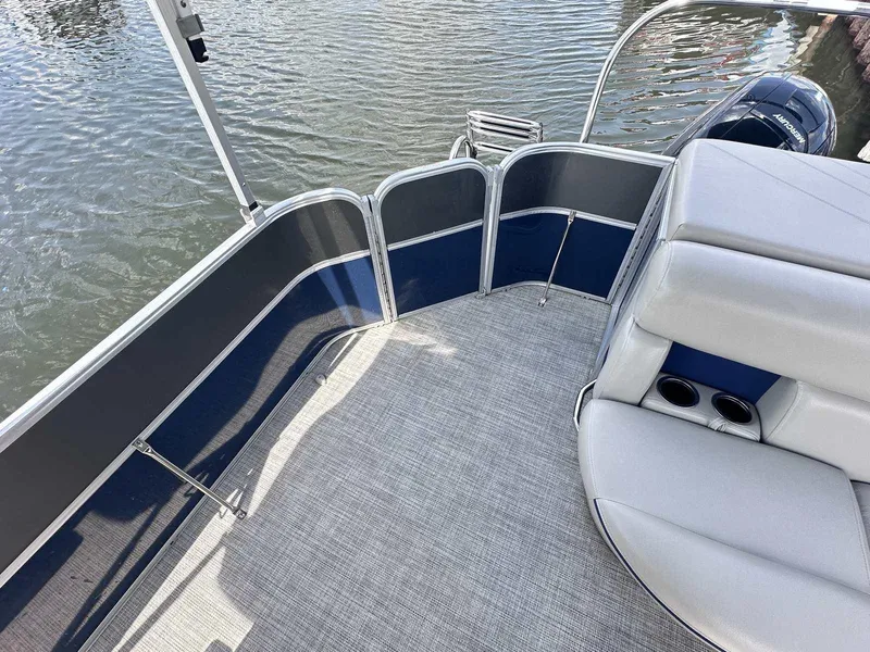 Slide: The Image of 2022 Trifecta 22 CL E pontoon boat interior with gray seating and blue accents on water. - 11