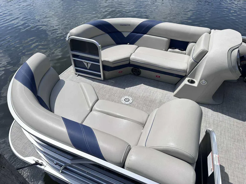 Slide: The Image of 2022 Trifecta 22 CL E pontoon boat with comfortable seating on calm water. - 2