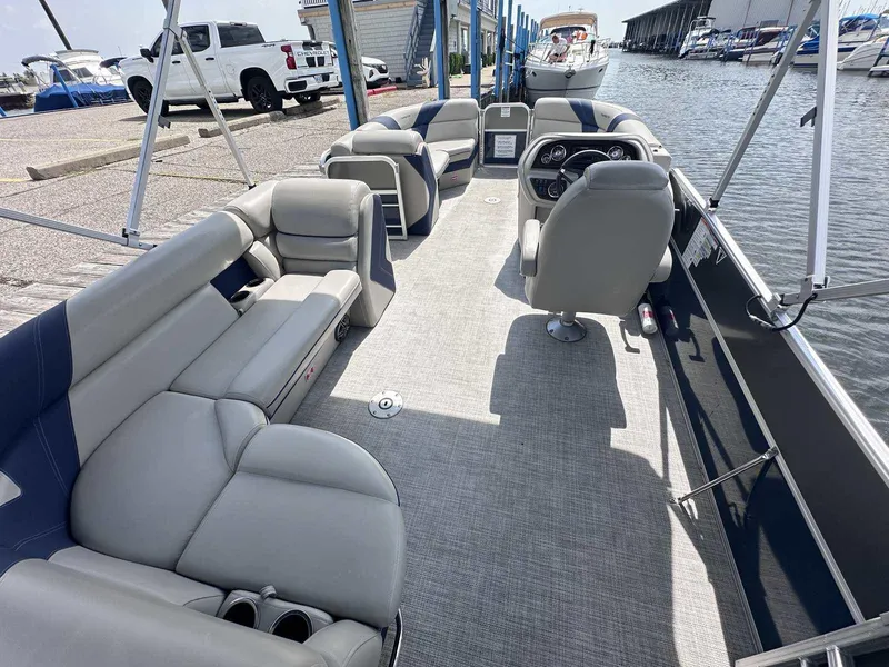 Slide: The Image of 2022 Trifecta 22 CL E pontoon boat interior with gray seating and steering console. - 7