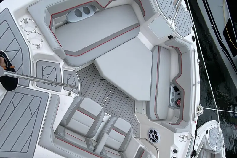 Slide: The Image of 2025 Solara S-310 CW boat interior with gray and red seating, cup holders, and speakers. - 10