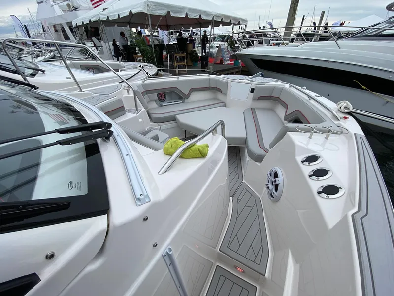 Slide: The Image of 2025 Solara S-310 CW boat interior with seating and cup holders at a marina. - 9