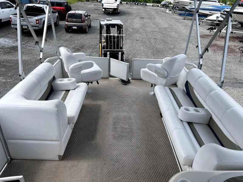 Slide: The Image of Interior of a 2006 Crest II pontoon boat with white seating and cup holders. - 5
