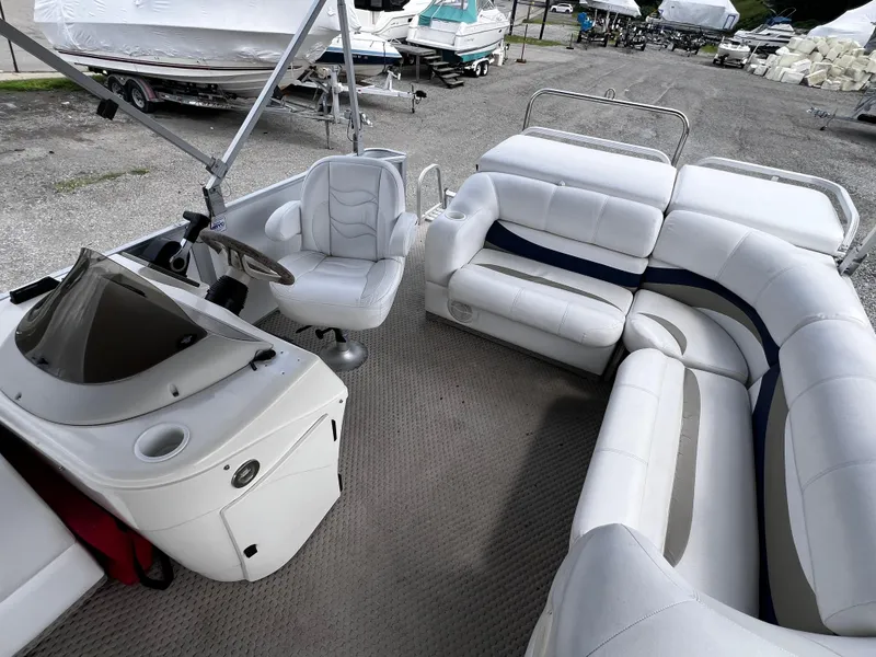 Slide: The Image of 2006 Crest II pontoon boat interior with white seating and steering console. - 6