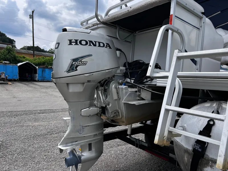 Slide: The Image of 2006 Crest II boat with Honda four-stroke outboard motor in a parking area. - 7