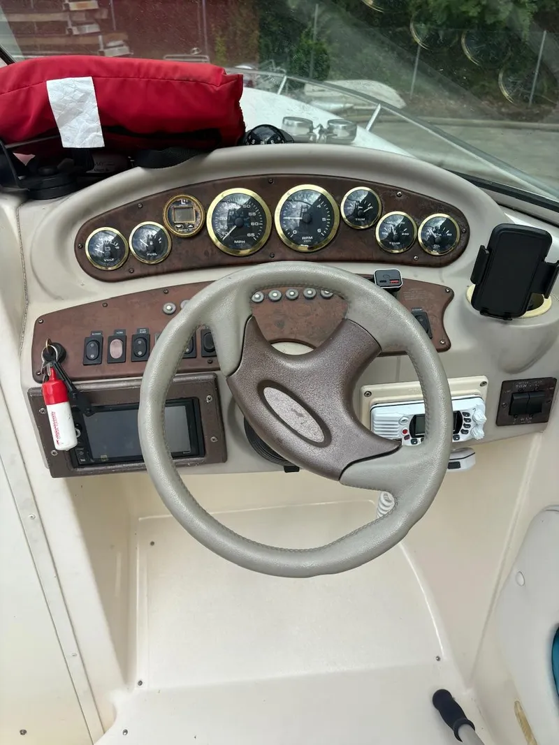 Slide: The Image of Steering console of a 2000 Rinker 272 Captiva Cuddy boat with gauges and controls. - 11