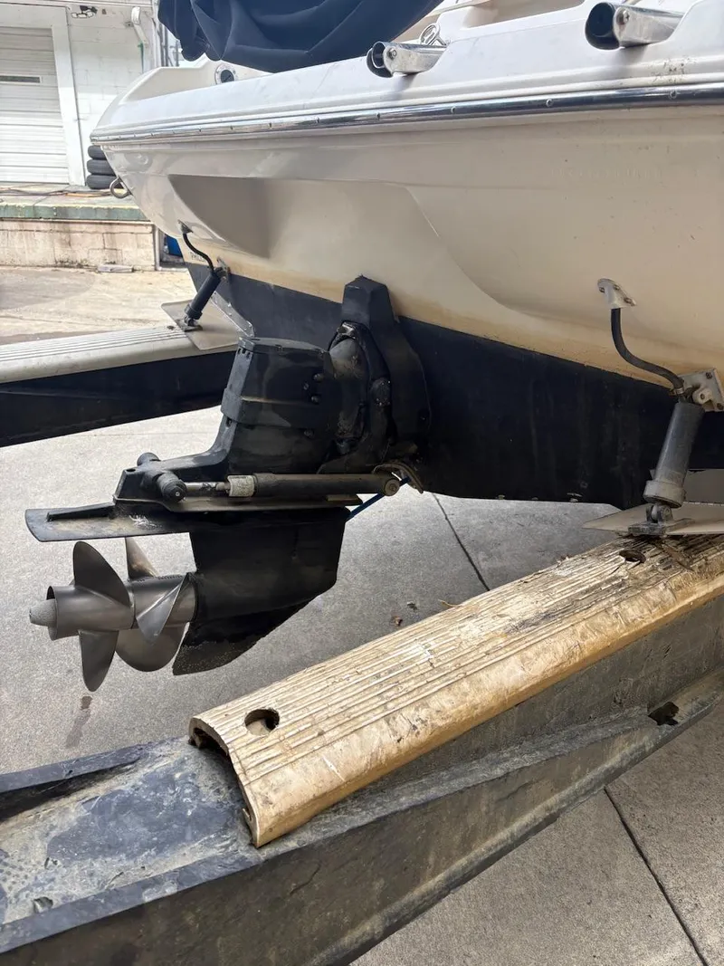 Slide: The Image of 2000 Rinker 272 Captiva Cuddy boat on trailer, showing propeller and stern drive. - 12
