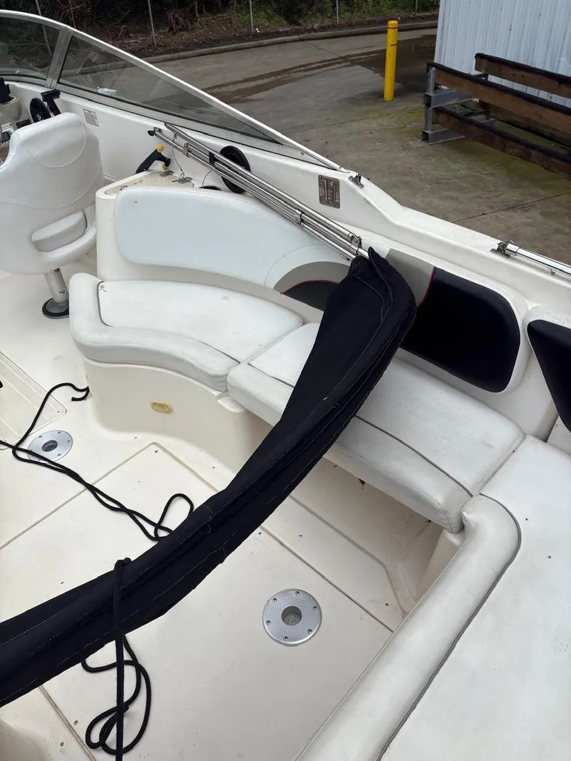 Slide: The Image of 2000 Rinker 272 Captiva Cuddy interior with white seating and deck details. - 9