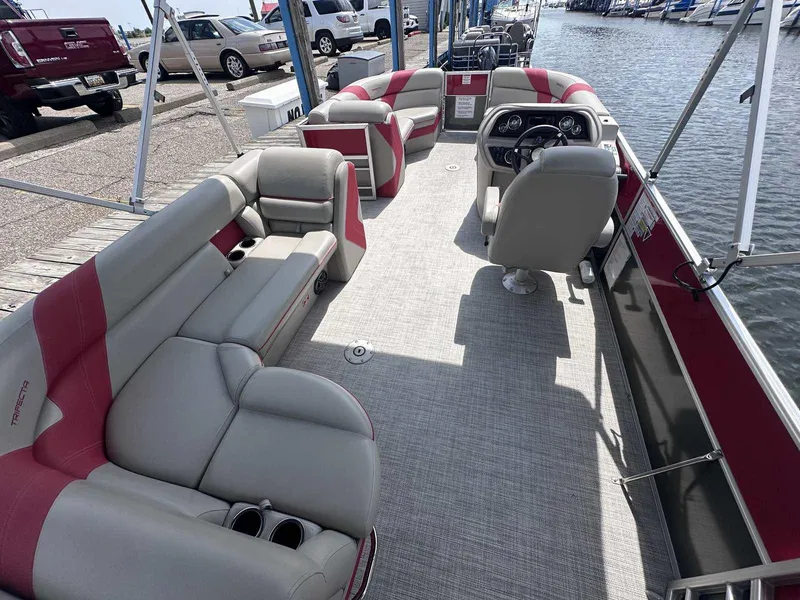 Slide: The Image of 2023 Trifecta 22 CLE 275 pontoon boat interior with plush seating and steering console. - 10