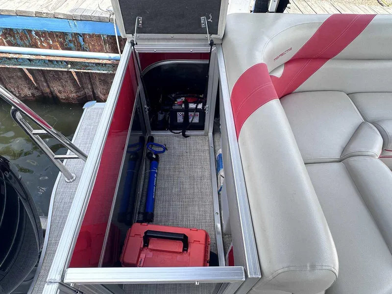 Slide: The Image of Open storage compartment on 2023 Trifecta 22 CLE 275 boat, featuring tools and equipment. - 12