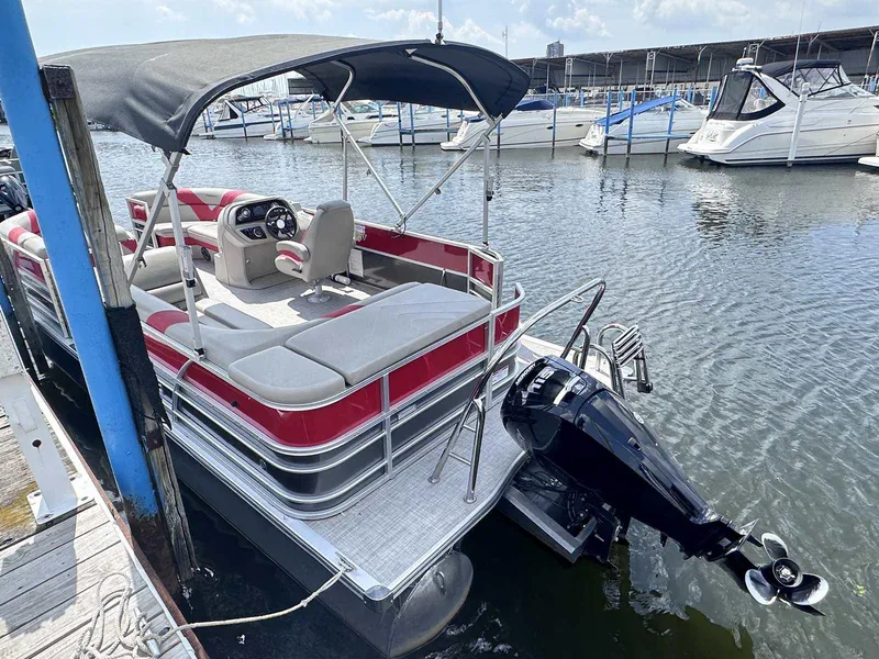 Slide: The Image of 2023 Trifecta 22 CLE 275 pontoon boat docked at marina, featuring canopy and outboard motor. - 13