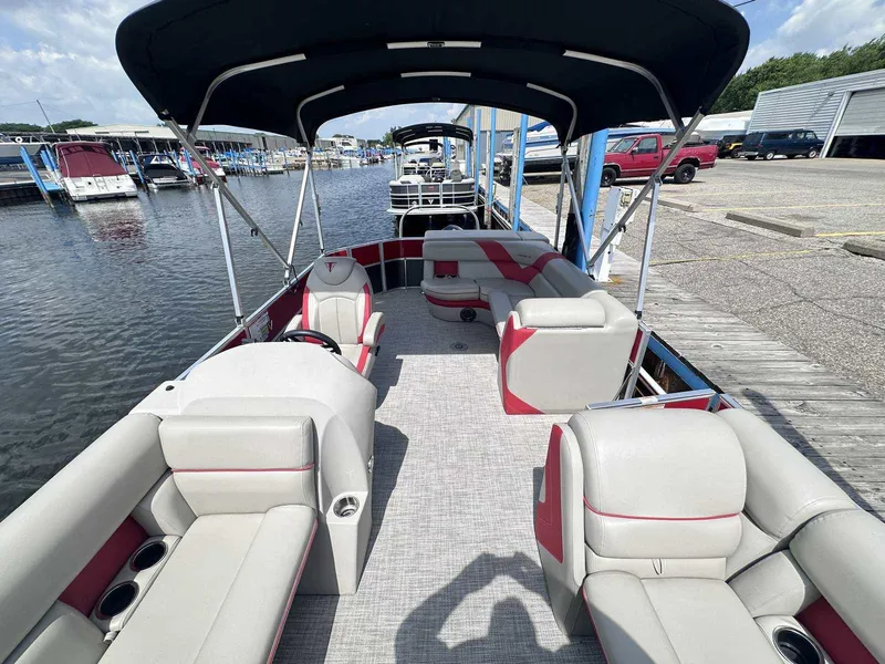 Slide: The Image of 2023 Trifecta 22 CLE 275 pontoon boat with spacious seating and canopy at a marina. - 6