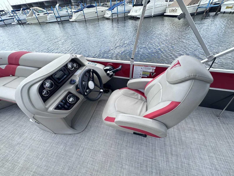 Slide: The Image of 2023 Trifecta 22 CLE 275 boat interior with steering wheel and captain's chair by the water. - 7