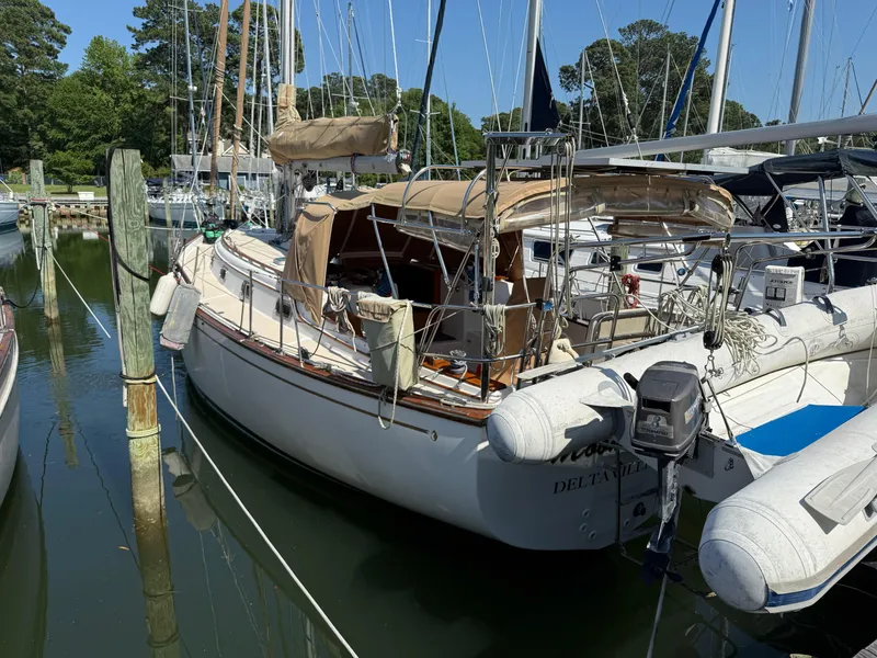 Slide: The Image of 1987 Island Packet 38 sailboat docked in a marina, surrounded by other boats. - 11