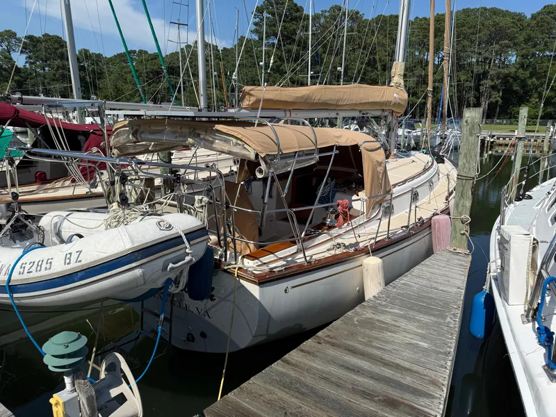Slide: The Image of 1987 Island Packet 38 sailboat docked with dinghy, surrounded by other boats. - 12