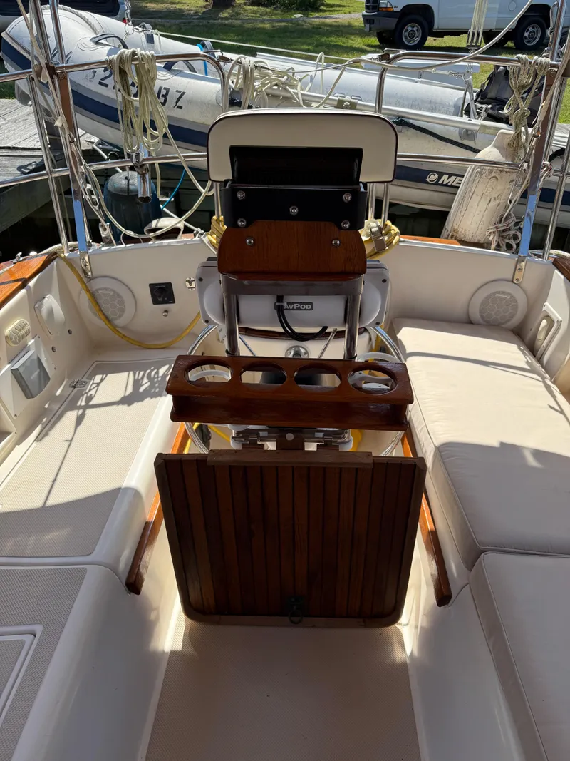 Slide: The Image of 1987 Island Packet 38 sailboat cockpit with seating, steering wheel, and cup holders. - 14
