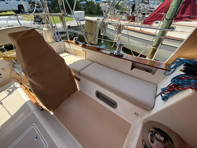 Slide: The Image of 1987 Island Packet 38 sailboat cockpit with seating, ropes, and covered equipment. - 15