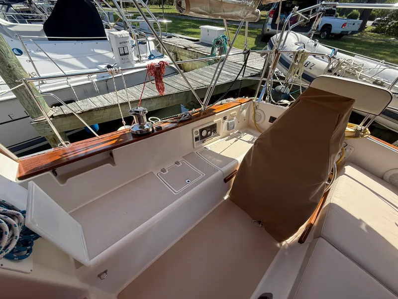 Slide: The Image of Cockpit of 1987 Island Packet 38 sailboat with covered helm and docked surroundings. - 16