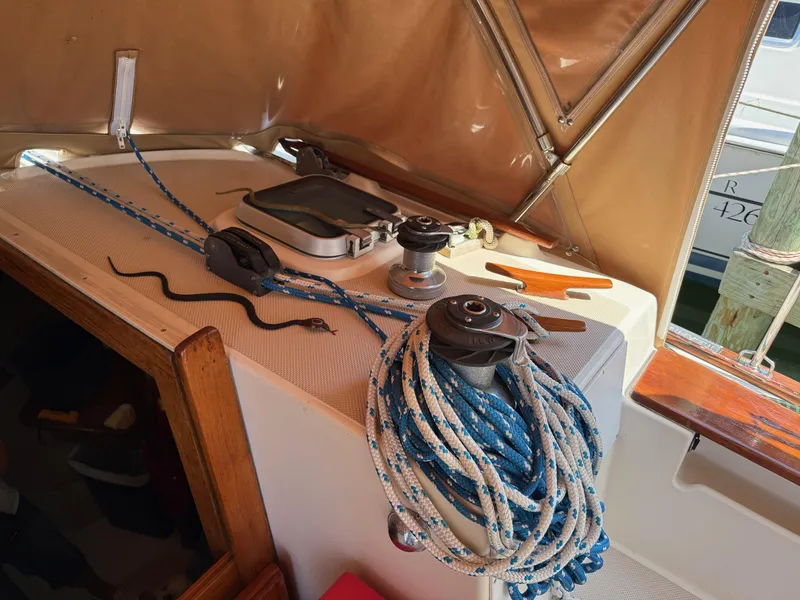 Slide: The Image of 1987 Island Packet 38 sailboat cockpit with ropes, winches, and a small snake on deck. - 18