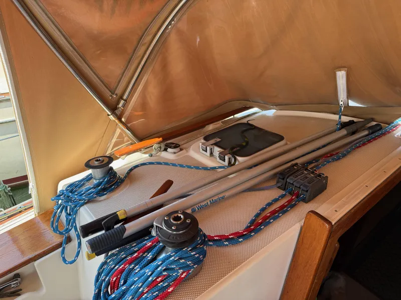 Slide: The Image of 1987 Island Packet 38 sailboat deck with ropes and equipment under a canopy. - 19