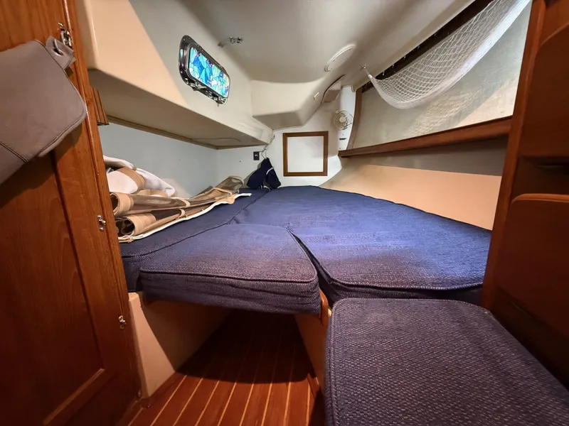 Slide: The Image of Cozy cabin interior of 1987 Island Packet 38 sailboat with blue cushions and wooden accents. - 23