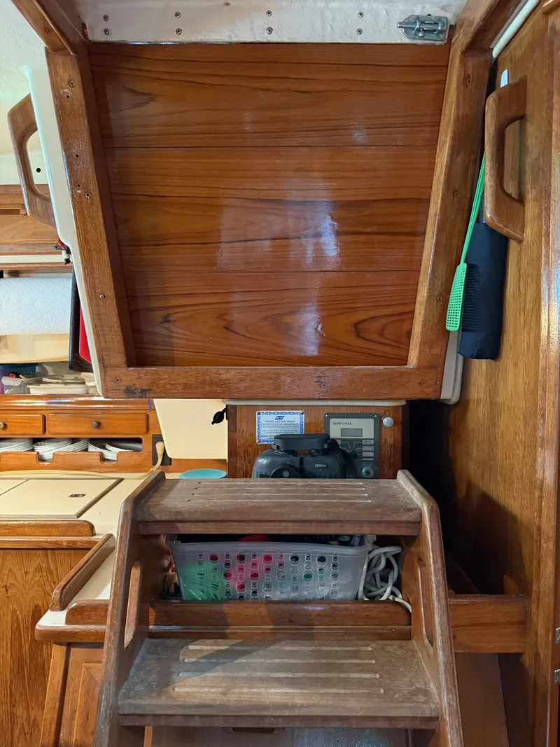 Slide: The Image of Interior of 1987 Island Packet 38 sailboat with wooden steps and storage area. - 25