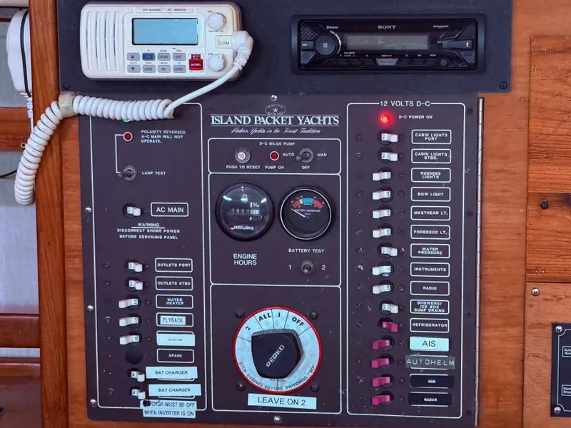Slide: The Image of Control panel of a 1987 Island Packet 38 yacht with various switches and gauges. - 28