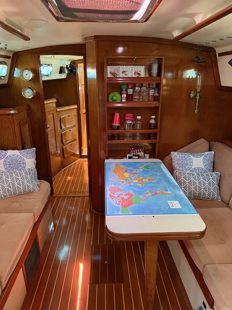 Slide: The Image of Interior of 1987 Island Packet 38 sailboat with map on table and cozy seating. - 32