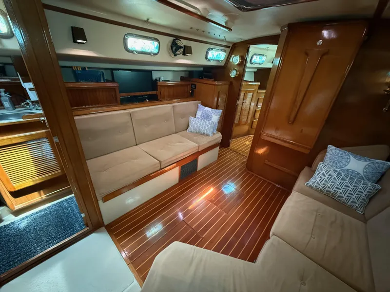 Slide: The Image of Interior of 1987 Island Packet 38 sailboat with wooden flooring and beige seating. - 34