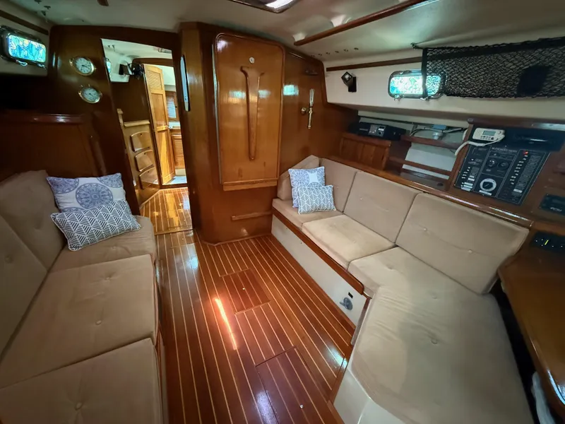 Slide: The Image of Interior of 1987 Island Packet 38 sailboat with wooden flooring and beige seating. - 35