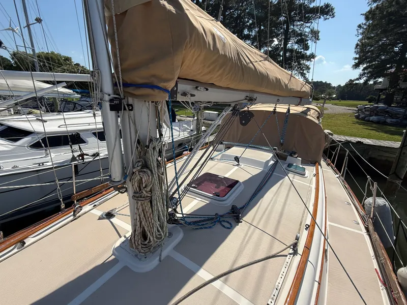 Slide: The Image of 1987 Island Packet 38 sailboat deck with rigging and tan sail cover, docked at marina. - 4