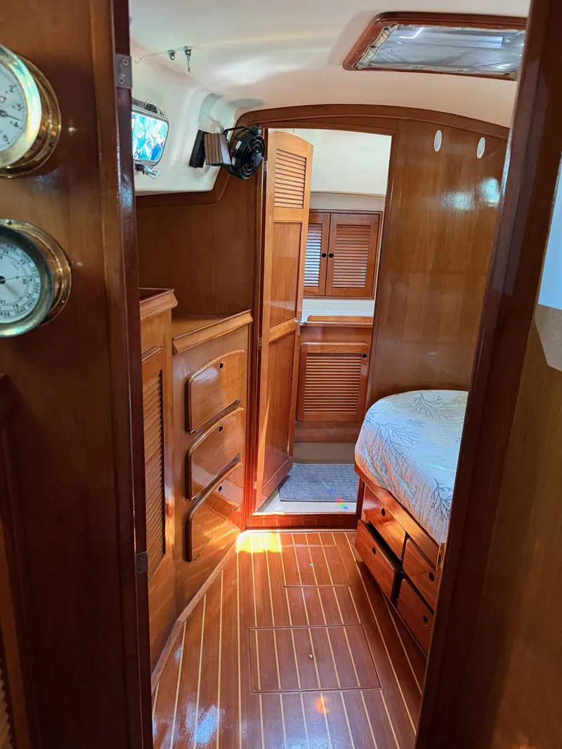 Slide: The Image of Interior of 1987 Island Packet 38 sailboat with wooden cabinetry and cozy sleeping area. - 40