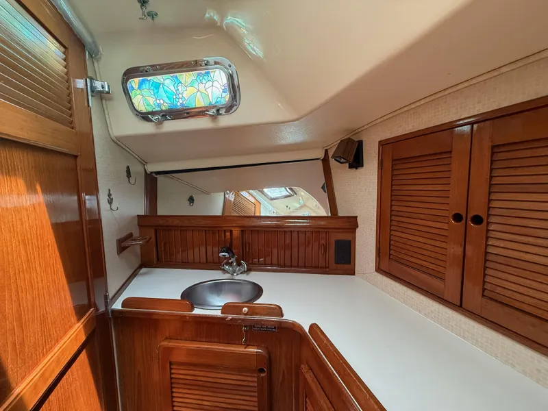 Slide: The Image of 1987 Island Packet 38 yacht interior with wooden cabinetry and stained glass window. - 41