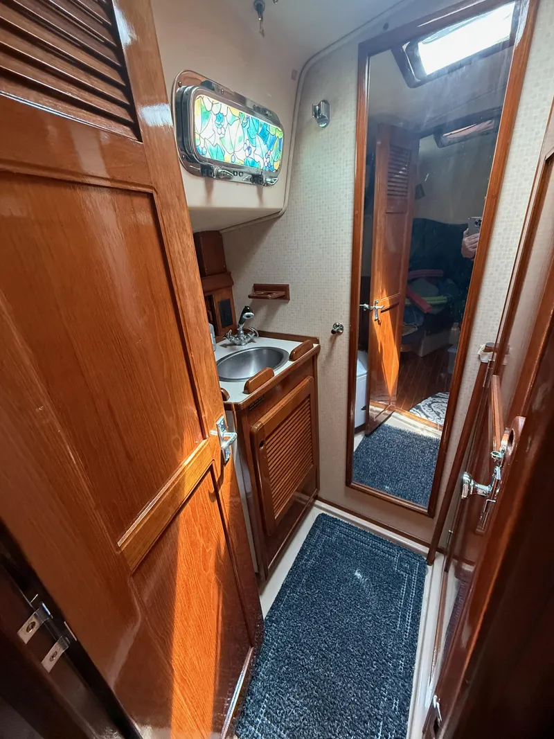 Slide: The Image of 1987 Island Packet 38 yacht interior with wooden cabinetry, sink, and mirror. - 47