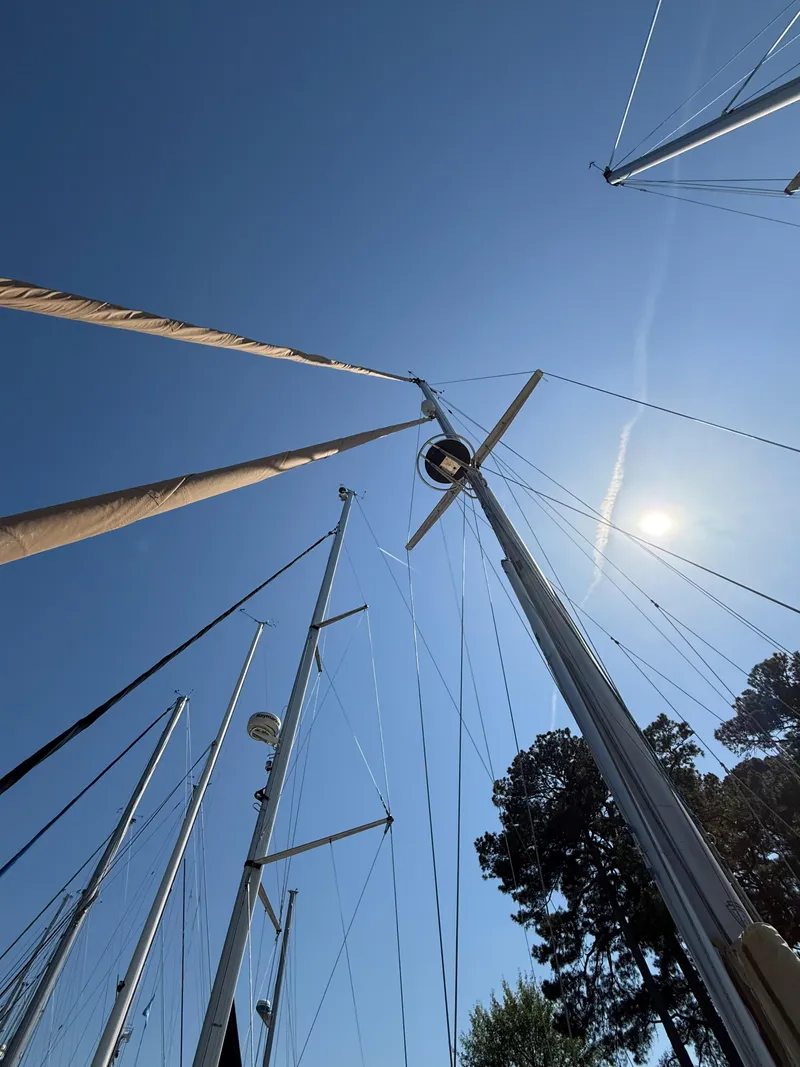 Slide: The Image of Masts of 1987 Island Packet 38 sailboat against clear blue sky. - 5