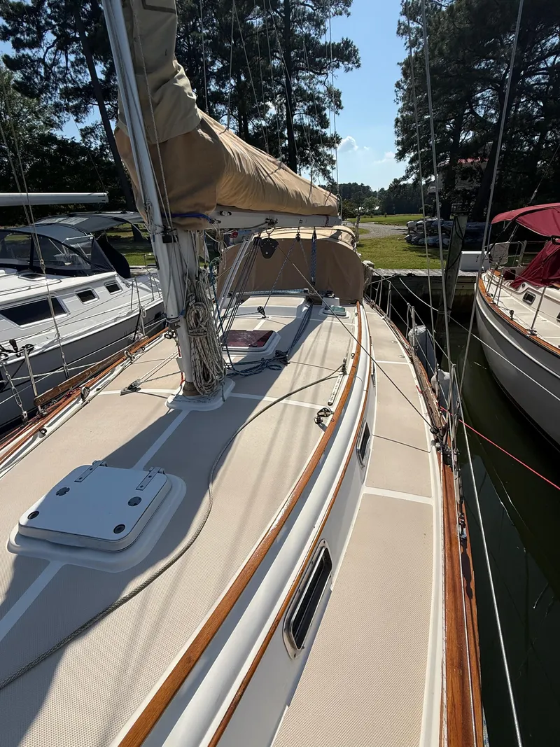 Slide: The Image of 1987 Island Packet 38 sailboat docked, showcasing deck and rigging under clear skies. - 6