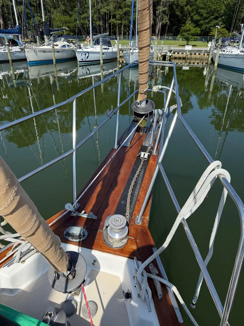 Slide: The Image of Bow of 1987 Island Packet 38 sailboat docked in a marina, showing anchor chain and railing. - 8