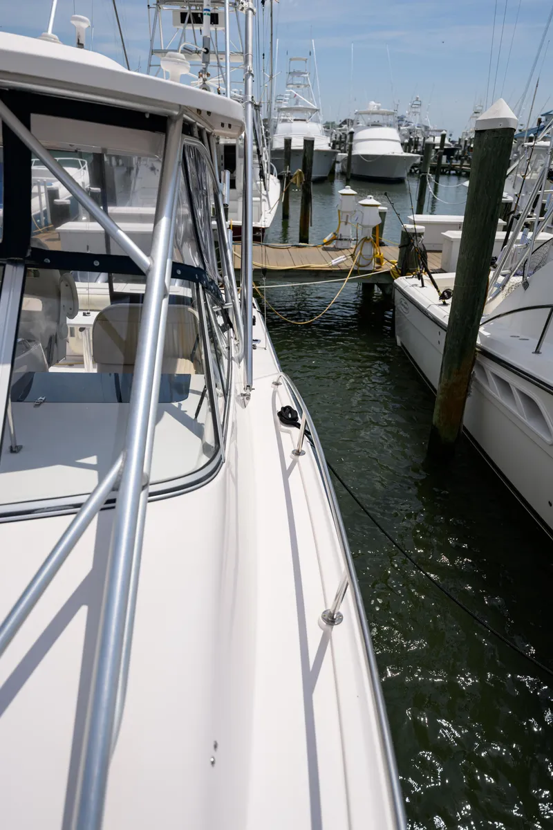 Slide: The Image of 2003 Grady-White Express 330 docked at a marina, surrounded by other boats. - 26