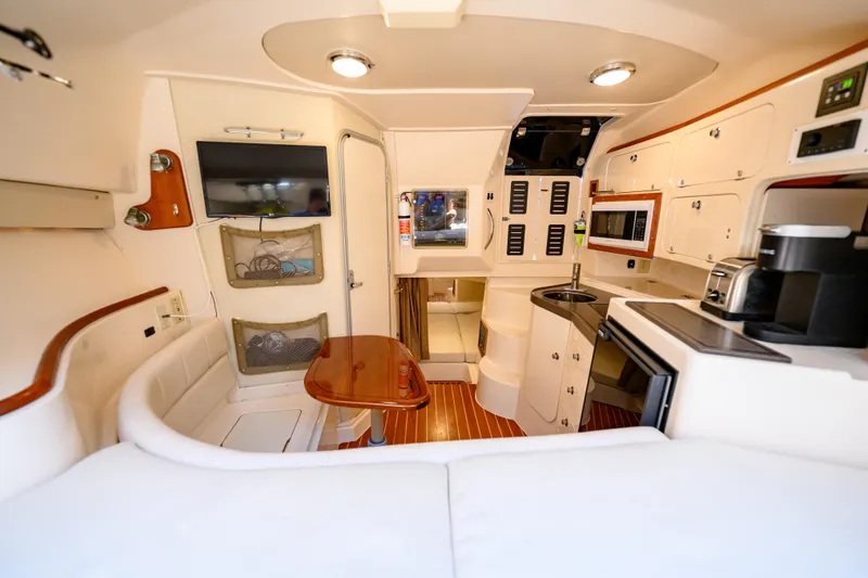 Slide: The Image of Interior of 2003 Grady-White Express 330 boat, featuring kitchen, seating, and modern amenities. - 20