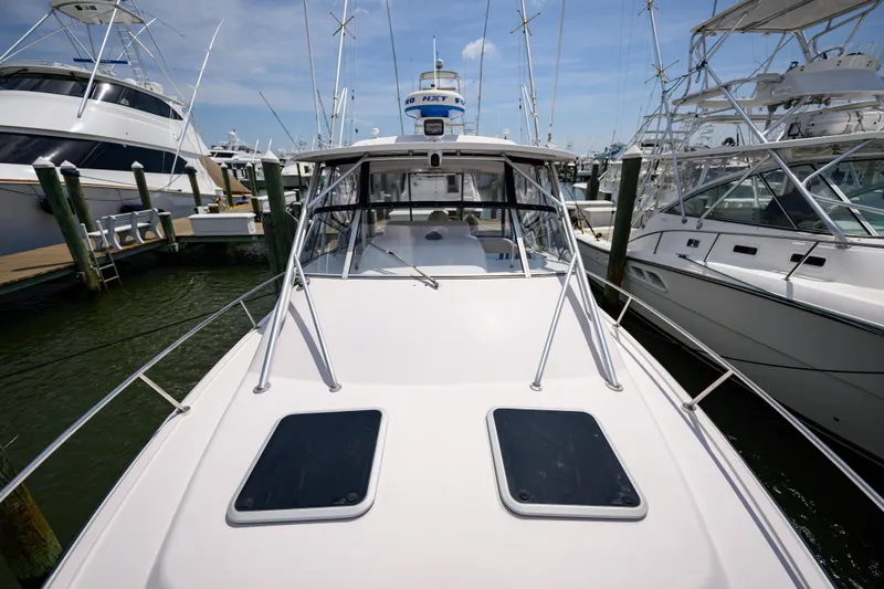 Slide: The Image of 2003 Grady-White Express 330 boat docked at marina, surrounded by other vessels. - 25