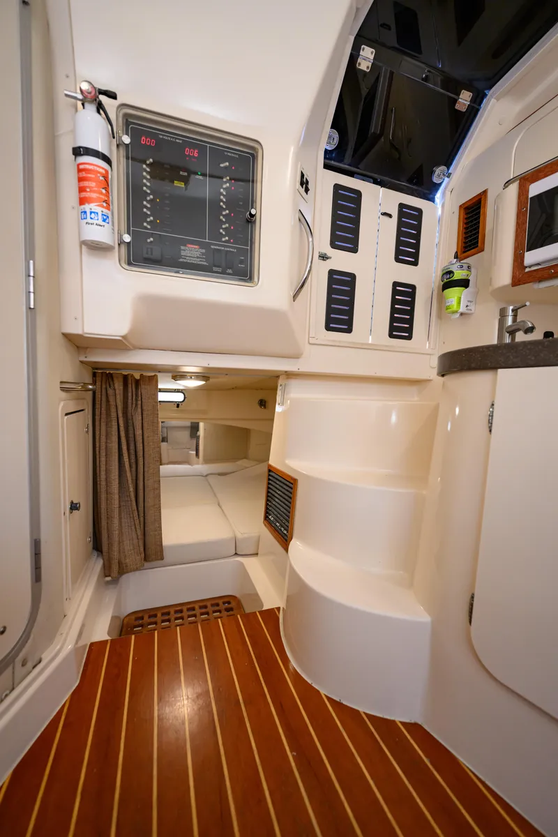Slide: The Image of Interior of 2003 Grady-White Express 330 boat, featuring cabin, control panel, and wooden flooring. - 21