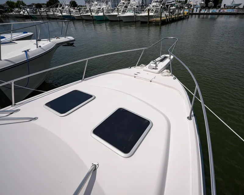 Slide: The Image of 2003 Grady-White Express 330 boat docked at marina, showing bow and hatches. - 22