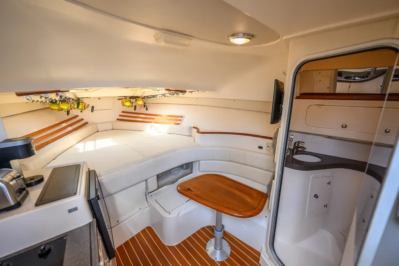 Slide: The Image of 2003 Grady-White Express 330 cabin interior with seating, table, and kitchenette. - 14