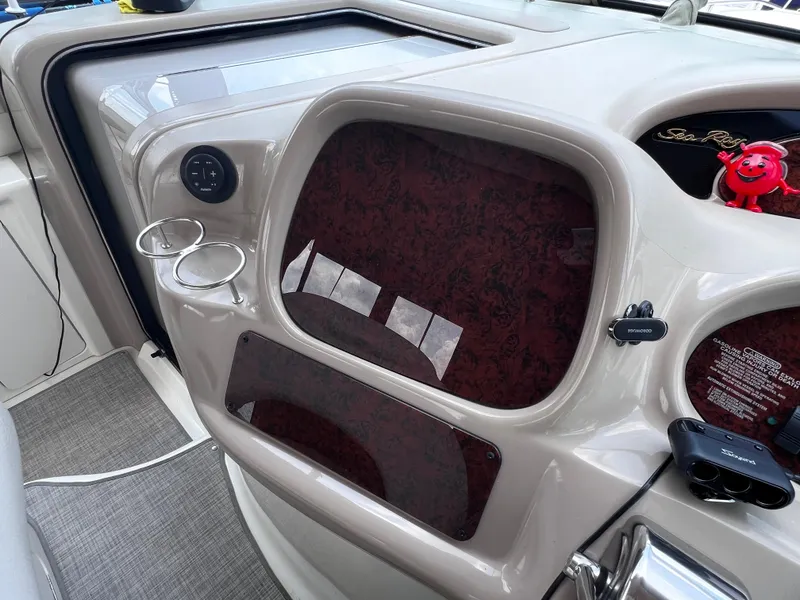 Slide: The Image of Dashboard of a 2000 Sea Ray 380 Sundancer boat with cup holders and controls. - 14