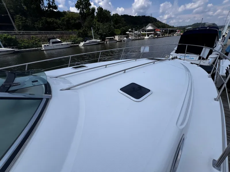 Slide: The Image of 2000 Sea Ray 380 Sundancer yacht docked at a marina under a partly cloudy sky. - 2