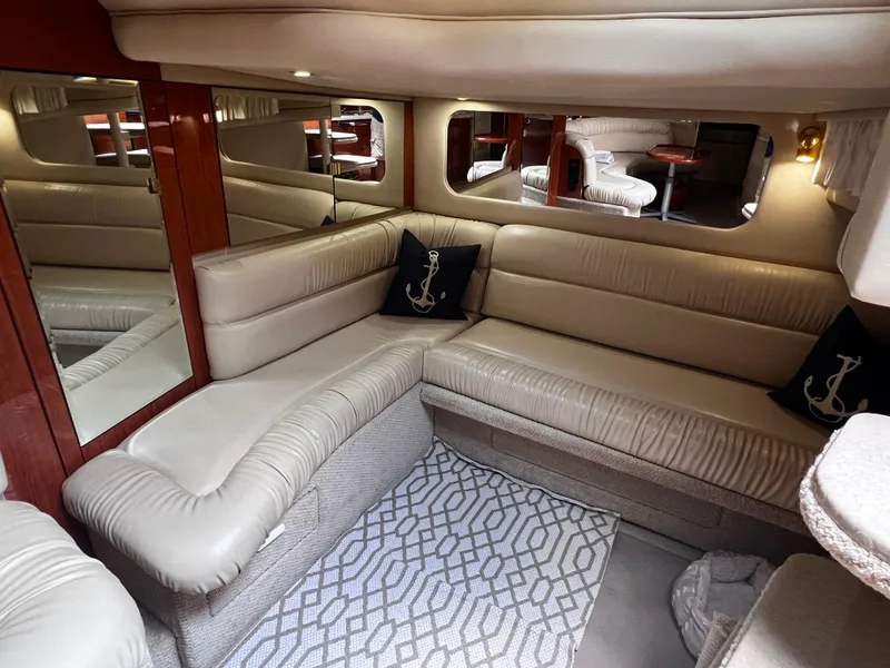 Slide: The Image of Interior of 2000 Sea Ray 380 Sundancer with beige leather seating and nautical decor. - 22